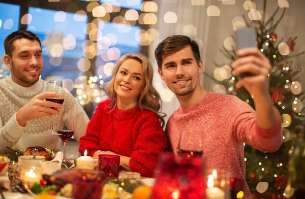 Przyjaciele biorąc selfie na świątecznej kolacji — Zdjęcie stockowe