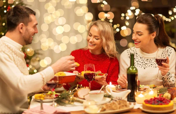 Amigos felices teniendo la cena de Navidad en casa — Foto de Stock