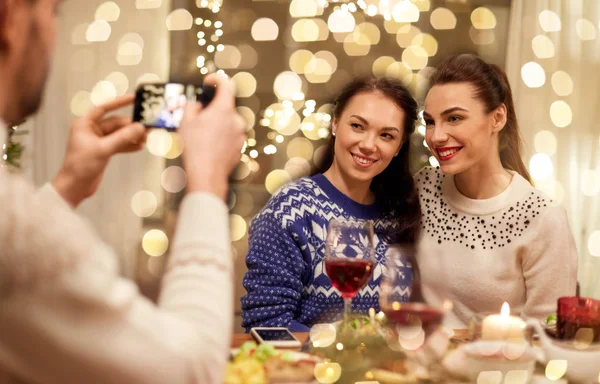 Amigos que têm jantar de Natal e tirar fotos — Fotografia de Stock