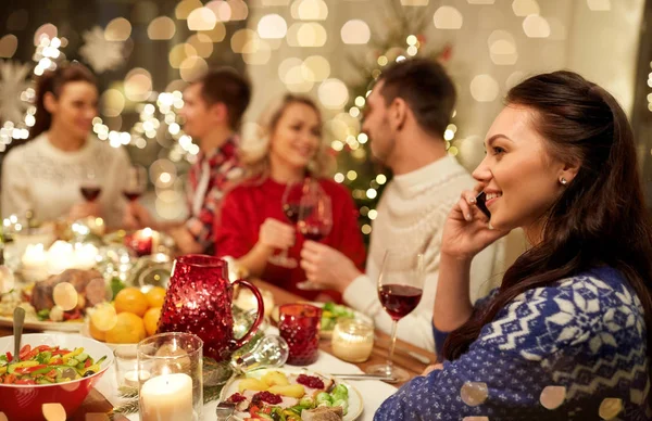 Frau telefoniert beim Weihnachtsessen mit Smartphone — Stockfoto