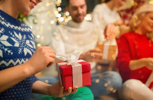 Close up of friends opening christmas gifts — Stock Photo, Image