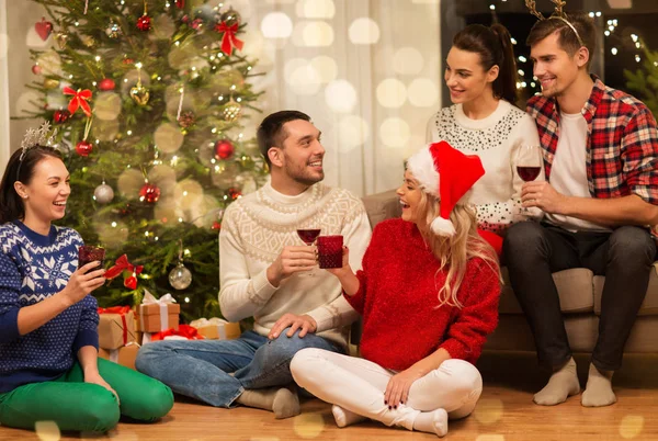 Amigos comemorando o Natal e beber vinho — Fotografia de Stock