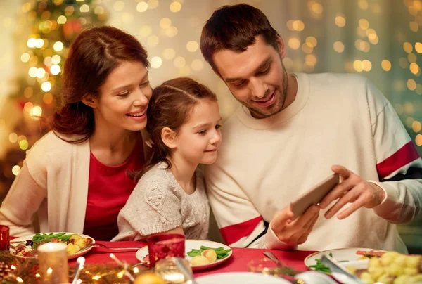 Akıllı telefonlu bir aile Noel yemeği yiyor. — Stok fotoğraf