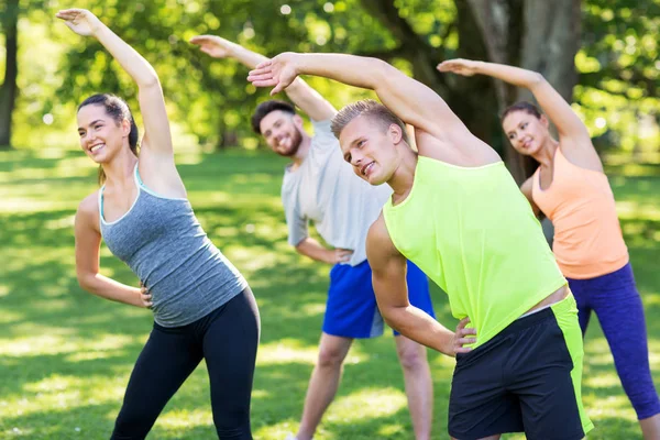 Yaz parkında egzersiz yapan bir grup mutlu insan. — Stok fotoğraf