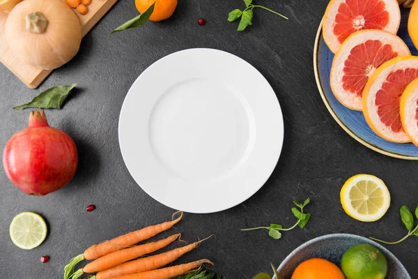 盘子、蔬菜和水果放在石板桌上 — 图库照片