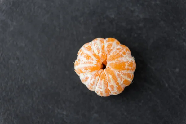 Close up of peeled mandarin on slate table top — Stock Photo, Image