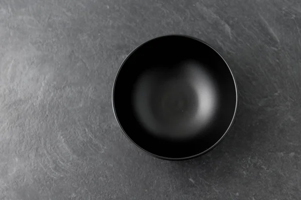 Black ceramic plate on slate background — Stock Photo, Image