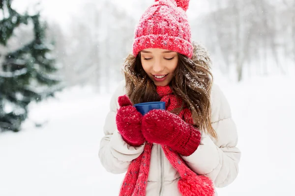 Glückliche junge Frau mit Teetasse im Winterpark — Stockfoto