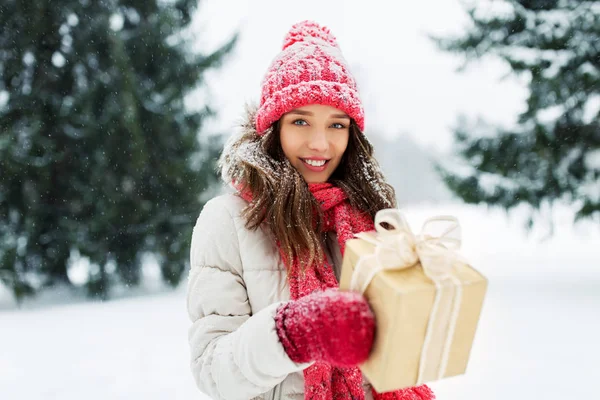 Glückliche junge Frau mit Weihnachtsgeschenk im Winter — Stockfoto