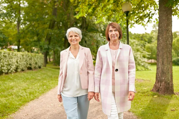 Mujeres mayores o amigos caminando por el parque de verano — Foto de Stock