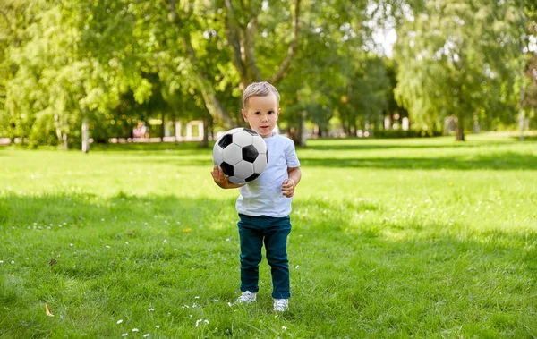 Yaz parkında elinde futbol topu olan küçük bir çocuk. — Stok fotoğraf