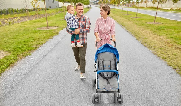 Rodina s dítětem a s kočárkem chůze po městě — Stock fotografie