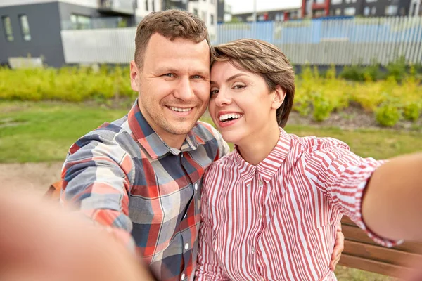 Lyckligt par i parken tar selfie utomhus Stockfoto
