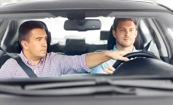Samochód szkoła jazdy instruktor ucząc męskiego kierowcy — Zdjęcie stockowe