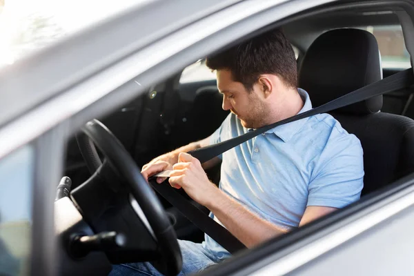 Мужчина или водитель автомобиля пристегивая ремень безопасности — стоковое фото