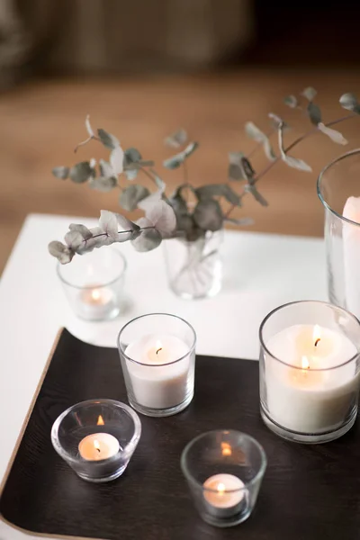 Płonące świece zapachowe na stole w przytulnym domu — Zdjęcie stockowe