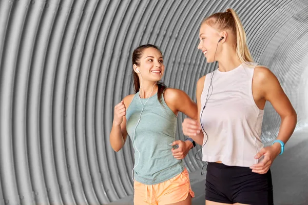 Mujeres o amigas con auriculares funcionando — Foto de Stock