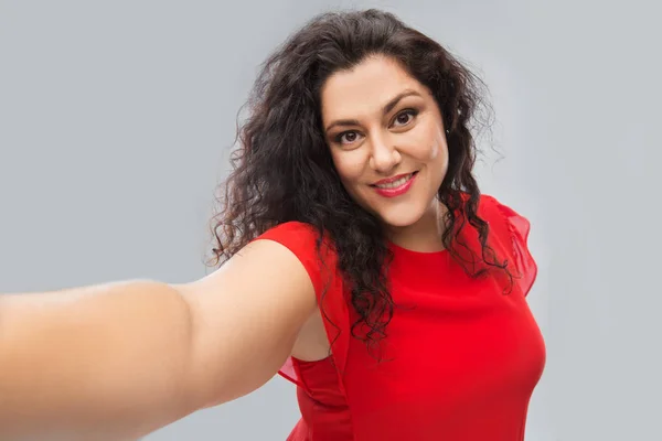 Mujer feliz en vestido rojo tomando selfie —  Fotos de Stock