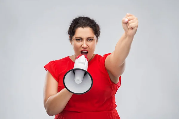 Kobieta w czerwonej sukience mówi do megafonu — Zdjęcie stockowe