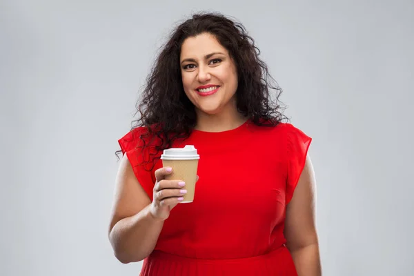 コーヒーカップを持っている赤いドレスの女性 ストック写真