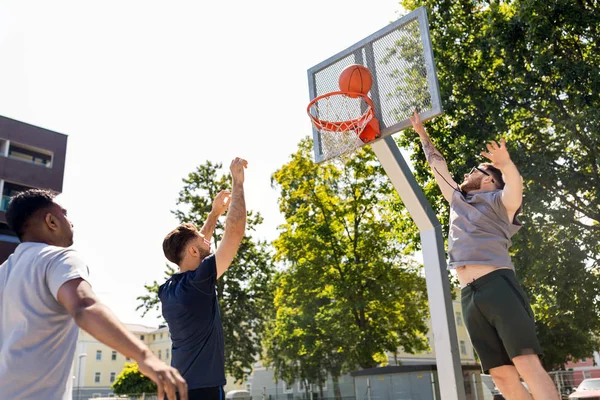 Группа друзей-мужчин, играющих в уличный баскетбол — стоковое фото