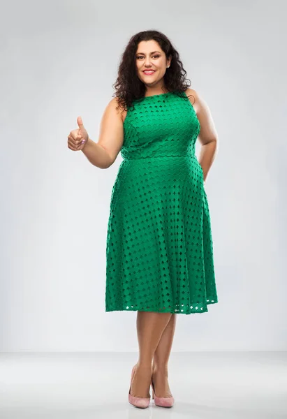 Gelukkig vrouw in groen jurk tonen duimen omhoog — Stockfoto