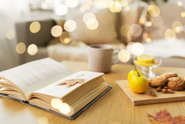 Libro, limón, té y galletas en la mesa en casa — Foto de Stock