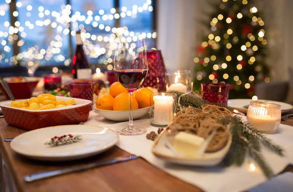 Glas rött vin och mat på julbordet — Stockfoto