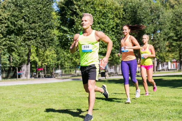 Felici giovani sportivi che corrono numeri di distintivo arguzia — Foto Stock