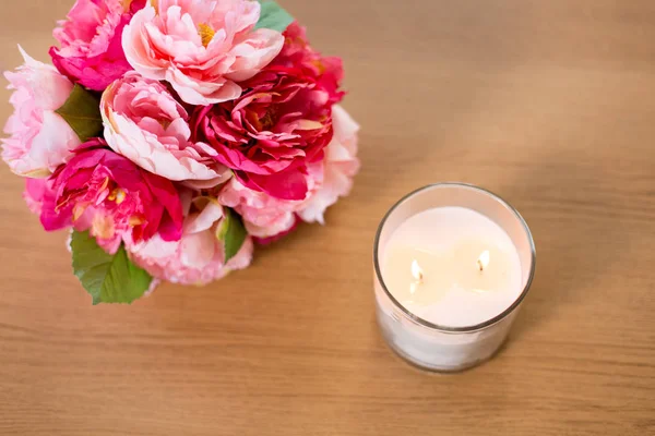 Brennende Duftkerze und Blumenstrauß auf Tisch — Stockfoto