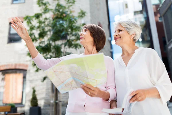 Senior women con guía de la ciudad y mapa en la calle — Foto de Stock