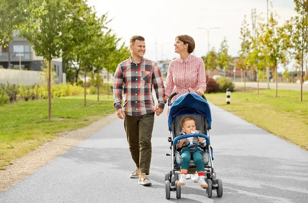 Familie met baby en wandelwagen wandelen langs de stad — Stockfoto