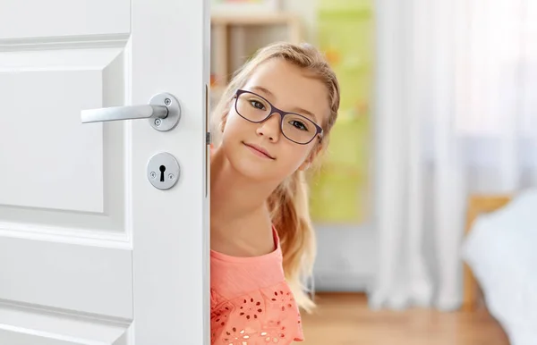 Bella ragazza l in occhiali dietro la porta a casa — Foto Stock