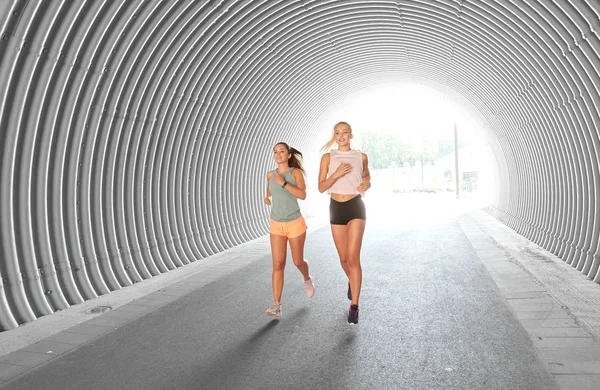 Young women or female friends running outdoors — Stock Photo, Image