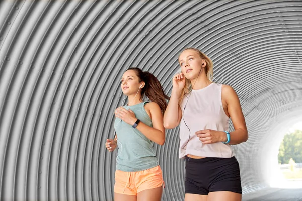 Mujeres o amigas con auriculares funcionando — Foto de Stock