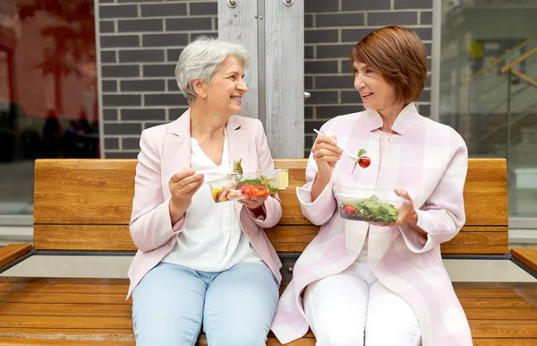 Senior vrouwen eten afhaalmaaltijden op City Street — Stockfoto