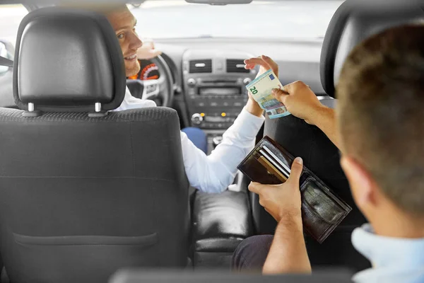 Male car driver taking money from passenger — Stock Photo, Image
