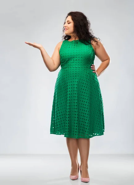 Mulher feliz em verde segurando algo na mão — Fotografia de Stock