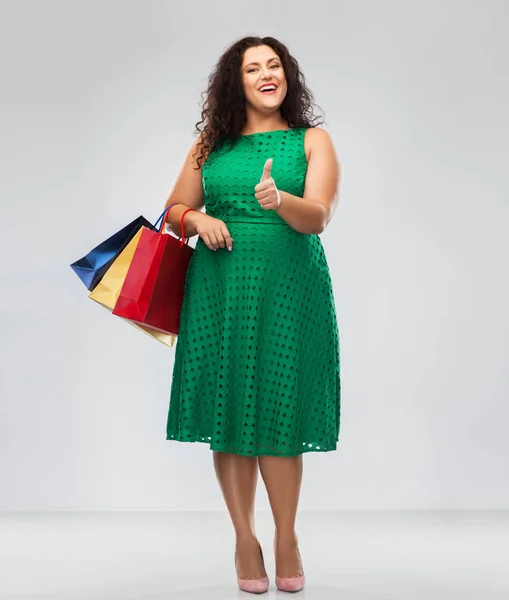 Mulher feliz com sacos de compras mostrando polegares para cima — Fotografia de Stock