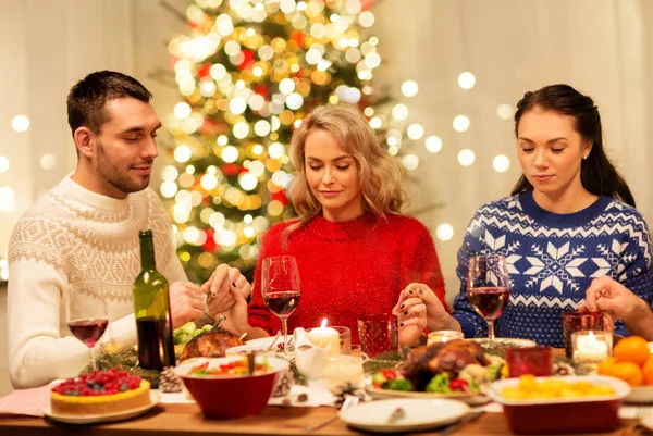 Amigos rezando antes do jantar de Natal em casa — Fotografia de Stock