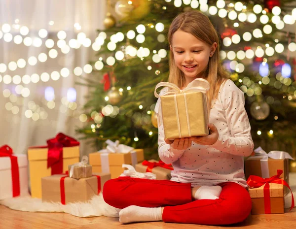 Leende flicka med julklapp hemma — Stockfoto