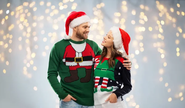 Heureux couple en chandails de Noël et chapeaux de Père Noël — Photo