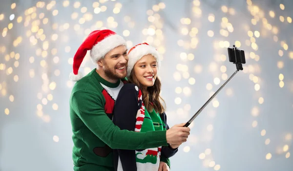 Felice coppia in maglioni di Natale prendendo selfie — Foto Stock