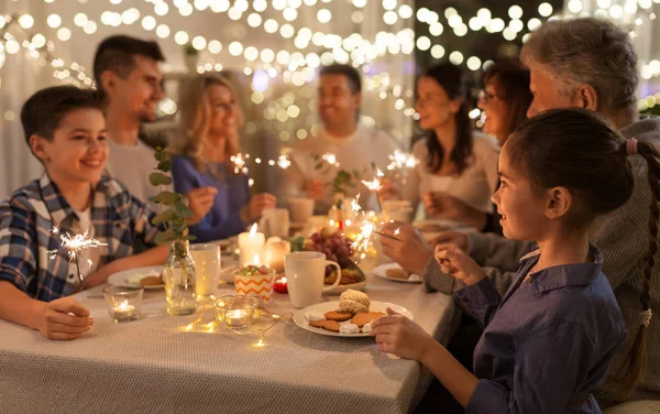 Family with sparklers having dinner party at home — Stock Photo, Image