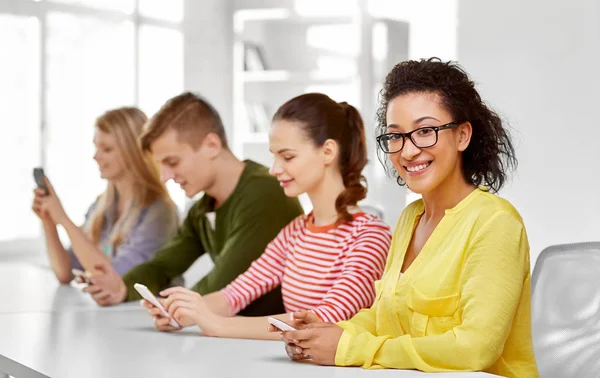 Estudantes do ensino médio felizes com smartphones — Fotografia de Stock