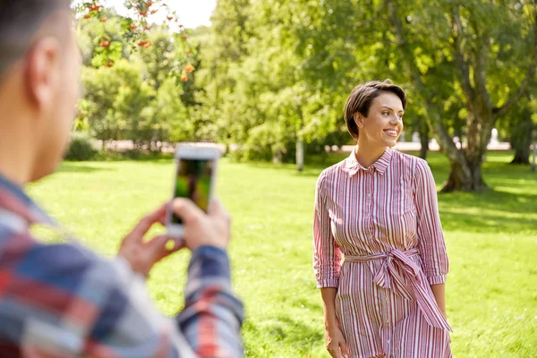 Koppel fotograferen met de smartphone in Park — Stockfoto