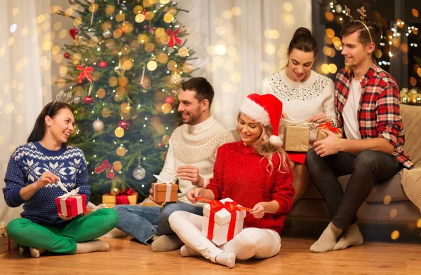 Amigos comemorando o Natal e abrindo presentes — Fotografia de Stock