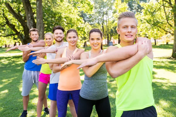 Grupo de personas felices haciendo ejercicio en el parque de verano —  Fotos de Stock