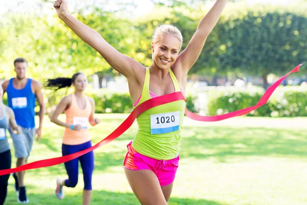 Feliz joven corredor femenino en la carrera de ganar final — Foto de Stock