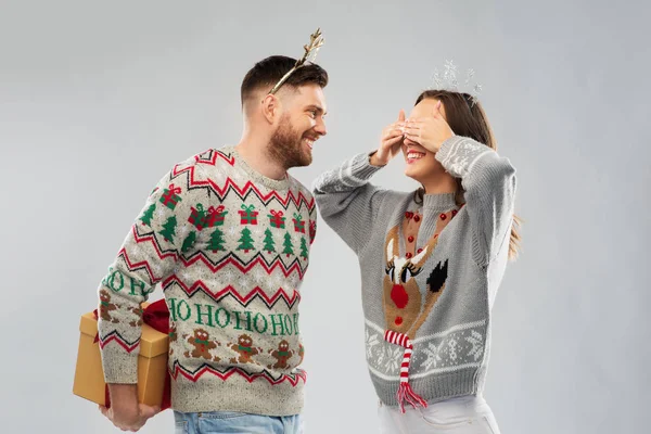 Ευτυχισμένο ζευγάρι σε χριστουγεννιάτικα πουλόβερ με κουτί δώρου — Φωτογραφία Αρχείου